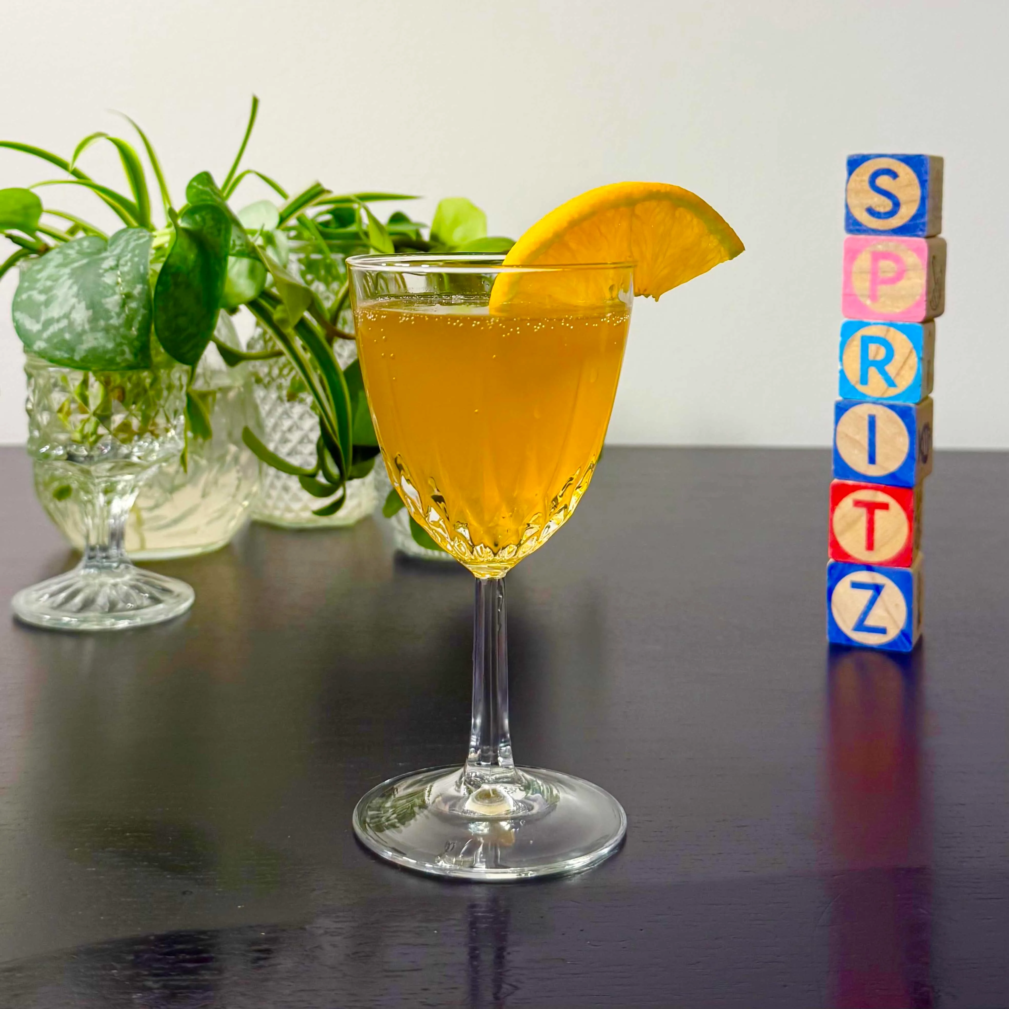 Tropical Fantasy cocktail of champagne, amaretto, pineapple juice, and orange juice in a stemmed glass garnished with an orange slice